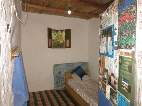 Habitación pequeña con cama y ventana en Le Sommet Naturel en Xauen