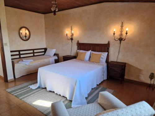 a bedroom with two beds and two chairs at Casinha da Pena - Tomar (Pedreira) in Tomar