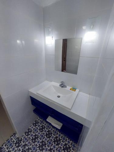 La salle de bains blanche est pourvue d'un lavabo et d'un miroir. dans l'établissement HN Hotel, à Durango
