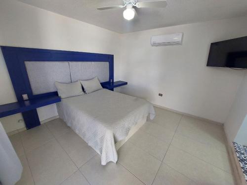 HN Hotel في ولاية دورانغو: غرفة نوم مع سرير مع اللوح الأمامي الأزرق