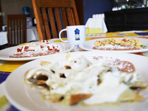 een tafel met drie borden eten en een kop koffie bij HN Hotel in Durango