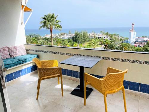 a table and chairs on a balcony with a view of the ocean at MEERBLICK BEACH-APARTMENT Monte Rojo in San Agustin