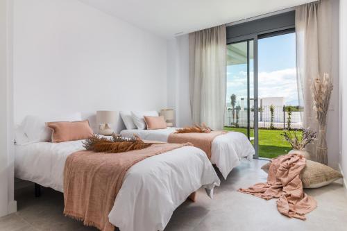 1 dormitorio con 2 camas y ventana grande en Exclusive New Apartment within Santa Clara and Marbella Golf & Country Club, en Marbella