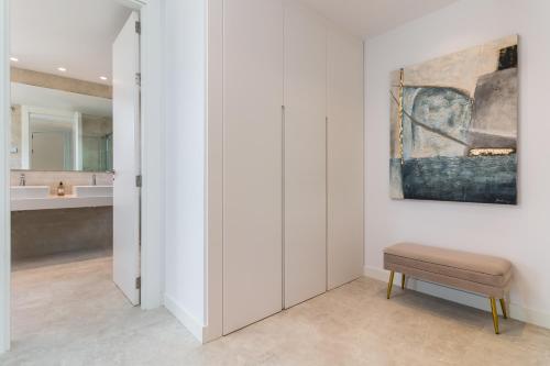 un baño con banco y una pintura en la pared en Exclusive New Apartment within Santa Clara and Marbella Golf & Country Club, en Marbella