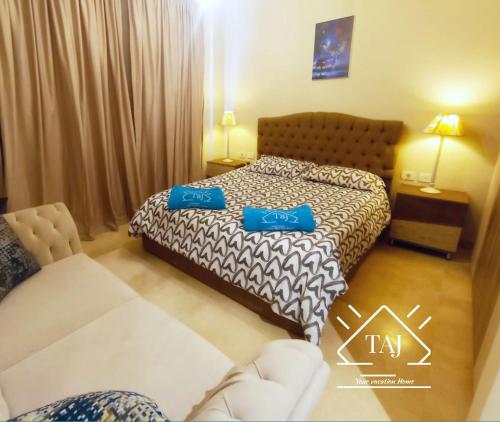 ein Hotelzimmer mit einem Bett mit zwei blauen Kissen in der Unterkunft Taj Home ,cozy mangroovy 2BR apartment..pool&Beach access in Hurghada