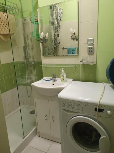 uma casa de banho com uma máquina de lavar roupa e um chuveiro em Stary Mokotów, blisko metra em Varsóvia
