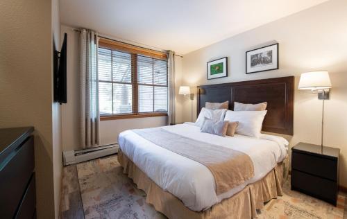 a bedroom with a large bed and a window at Zephyr Mountain Lodge Premium-Rated 1102 in Winter Park