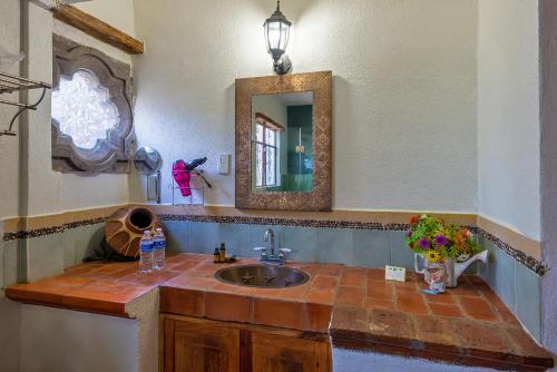 ein Bad mit einem Waschbecken und einem Spiegel in der Unterkunft Eco Hotel Ixhi in Pátzcuaro