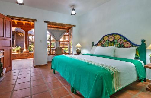 ein Schlafzimmer mit einem großen grünen Bett in einem Zimmer in der Unterkunft Eco Hotel Ixhi in Pátzcuaro