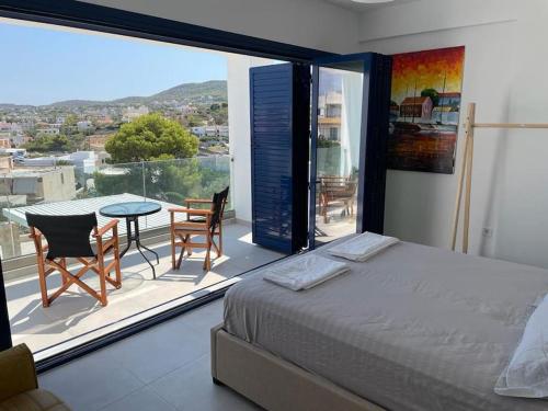 1 dormitorio con 1 cama y balcón con mesa y sillas en Souvala /Aegina. Excellent location Luxury villa., en Vathí