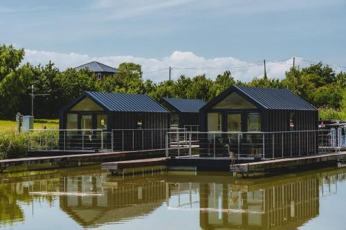 a row of black houses on the water at Whimbrel in Tattenhall