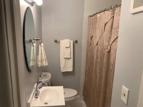 a bathroom with a sink and a toilet and a mirror at Modern cozy 1BD/1BA Apt in Federal Hill in Baltimore