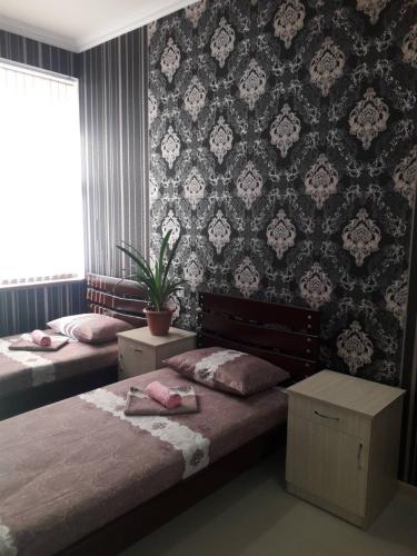 a bedroom with two beds and a wall at ERA Hotel in Gyumri