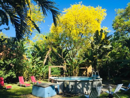 a garden with a hot tub and chairs and a tree at Naturalmente Boutique Bungalows y Cocina Mediterránea in Las Lajas