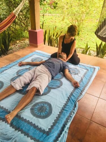 a man and a woman laying on top of a blanket at Naturalmente Boutique Bungalows y Cocina Mediterránea in Las Lajas