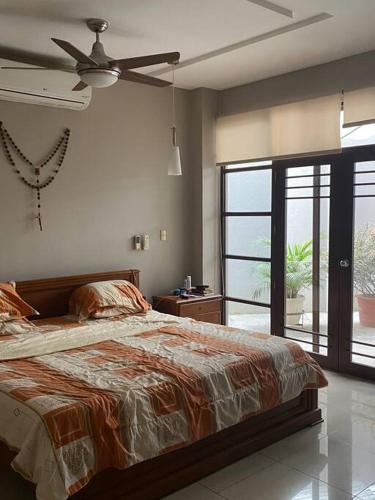 1 dormitorio con 1 cama y ventilador de techo en Linda suite para hospedarte en la Final, en Guayaquil