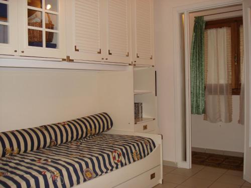 a room with a bed and a window and cabinets at Mimi House in Lido di Camaiore