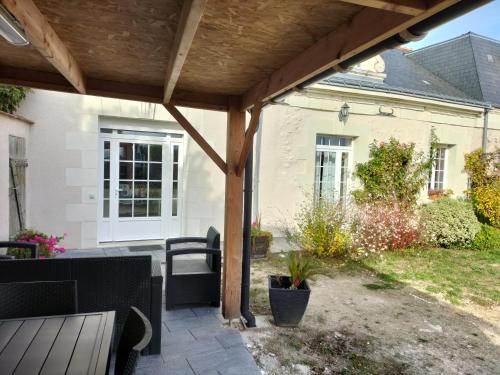 an outdoor patio with a wooden pergola at Le clos des augers. Chambre Descartes in Azay-sur-Cher