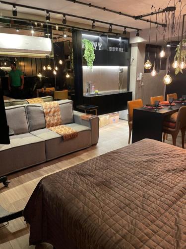 a living room with a couch and a dining room at Flat Moderno e decorado Lapa-RJ in Rio de Janeiro
