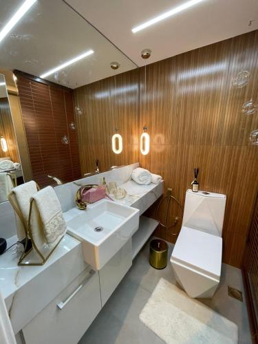 a bathroom with a sink and a toilet and a mirror at Flat Moderno e decorado Lapa-RJ in Rio de Janeiro