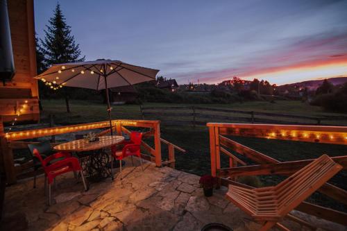 a patio with a table and chairs and an umbrella at Planinska kuća Isiteo in Kremna