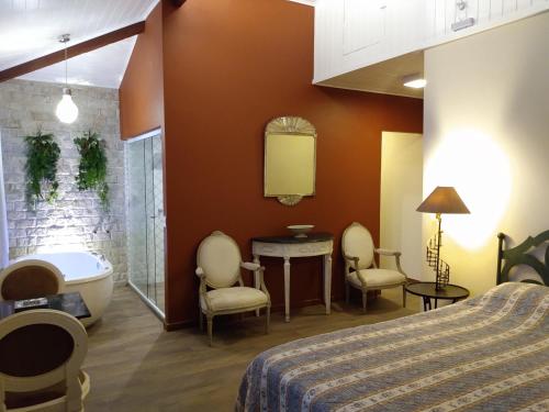 una camera con vasca e letto e un bagno di Pousada Quinta do Alto a Itaipava