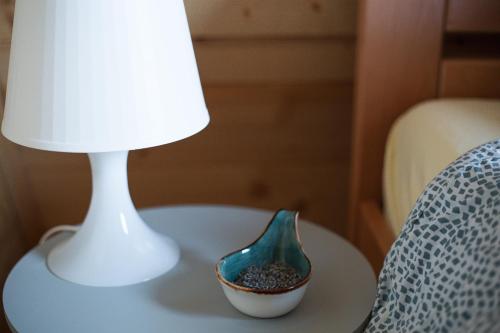 a lamp and a vase on a table next to a chair at Planinska kuća Isiteo in Kremna