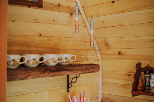 a wooden wall with cups on a shelf at Planinska kuća Isiteo in Kremna