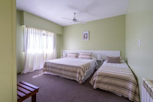 1 dormitorio con 2 camas y ventana en Hotel Arte del Rey en Pinamar