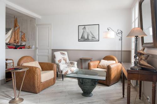 een woonkamer met 2 stoelen en een tafel bij Appartement L'Îlot au centre du port de Saint Martin in Saint-Martin-de-Ré