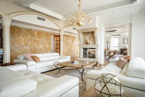 a living room with white furniture and a fireplace at King David Penthouse with private pool in Jerusalem