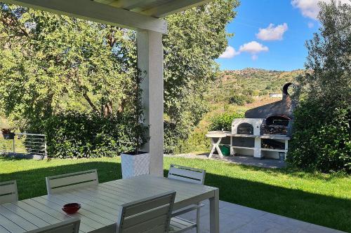 a table and chairs on a patio with a grill at Villa con piscina in Leonforte
