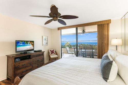 a bedroom with a bed and a flat screen tv at Holualoa Bay Villas#105 in Kailua-Kona