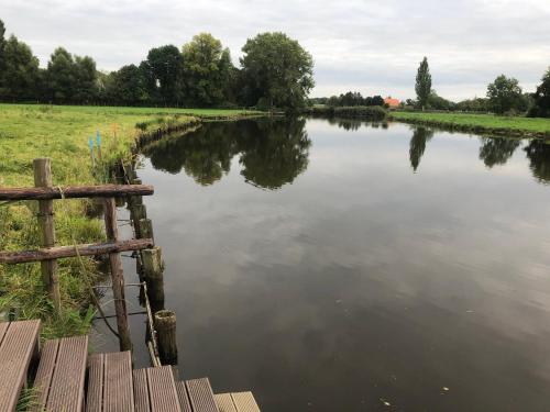 a view of a river with a wooden fence at Stedinger Landhotel & Café in Berne