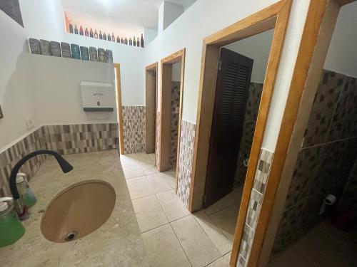 ein Bad mit einem Waschbecken, einer Dusche und einem Spiegel in der Unterkunft Casa São Lourenço in Bertioga