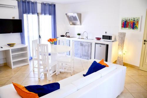 a living room with a white couch and a table at Branco Suites - Rooms & Holiday Apartments in Santa Maria