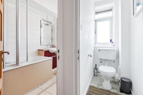biała łazienka z toaletą i umywalką w obiekcie Flat 13 w Londynie