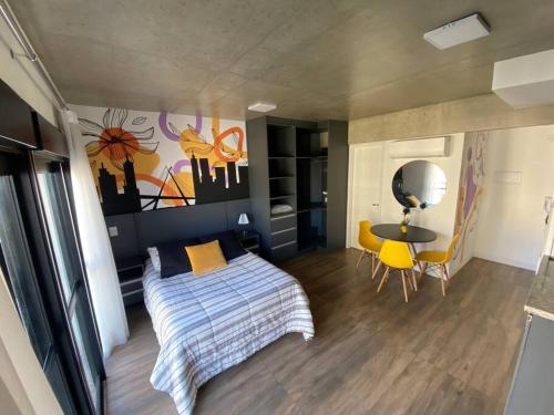 a bedroom with a bed and a table and yellow chairs at 92 New studio next Paulista Av, fast wifi and balcony in Sao Paulo