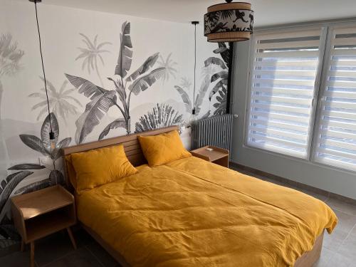 - une chambre avec un lit doté d'un couvre-lit jaune dans l'établissement Suite "Olga 1 ", à Verdun-sur-Meuse