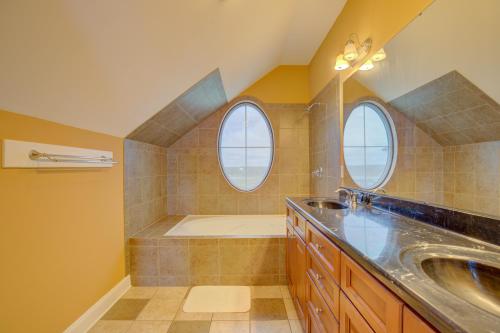 a bathroom with a sink and a tub and two windows at The Lazy Beagle in North Topsail Beach