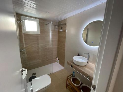 a bathroom with a tub and a sink and a mirror at Villa Can Simo Menorca in Punta Prima