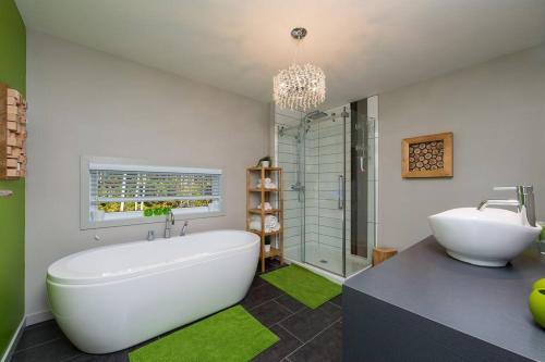 a bathroom with a large white tub and a sink at Le Chic Chac - Chalet in Petite-Rivière-Saint-François
