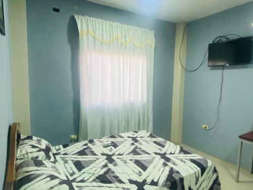 a bedroom with a bed in front of a window at Mi Gran Victoria in Manta