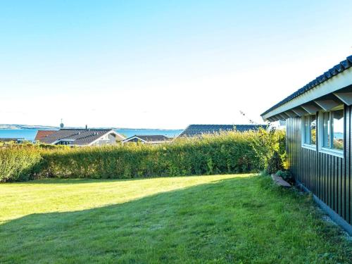 un patio junto a una casa con césped verde en 6 person holiday home in R nde, en Rønde