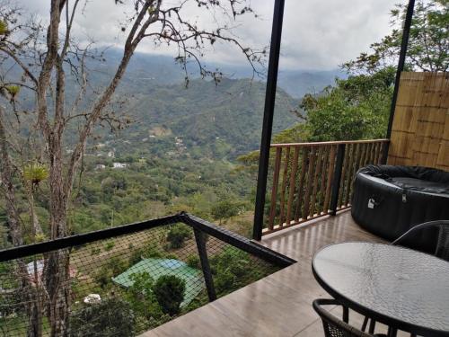 a balcony with a table and a view of the mountains at Glamping Bellavista in La Vega