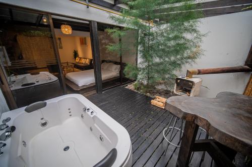 Un baño con bañera sobre una terraza de madera. en Vistas del Conde, en Heredia