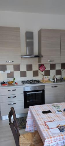 uma cozinha com uma mesa e um fogão forno superior em Piccola LoLu em Ortona