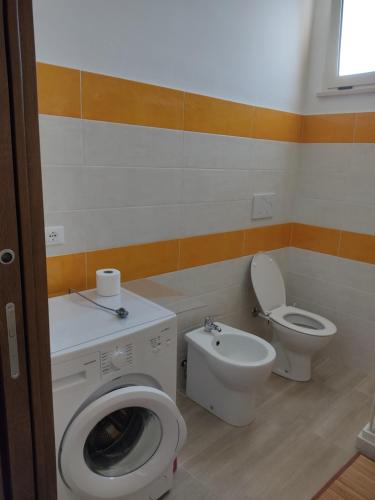 ein Badezimmer mit einer Waschmaschine und einem WC in der Unterkunft Piccola LoLu in Ortona