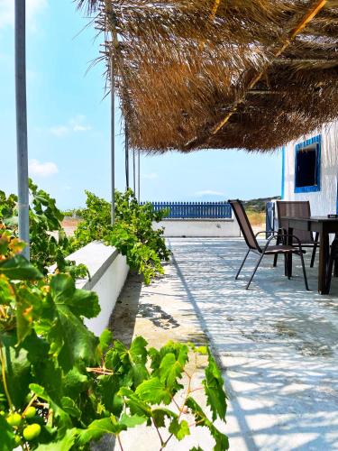 un patio con mesa y sillas en la playa en Tetrapolis cottage en Kárpatos