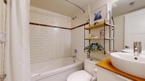 a bathroom with a tub and a sink and a toilet at 1BR plus Den Village Condo with Mountain Views and Hot Tub by Harmony Whistler in Whistler